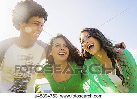 Group of friends (14-15) embracing and laughing View Large Photo Image Stock Image - Group of friends (14-15) embracing and laughing. Fotosearch