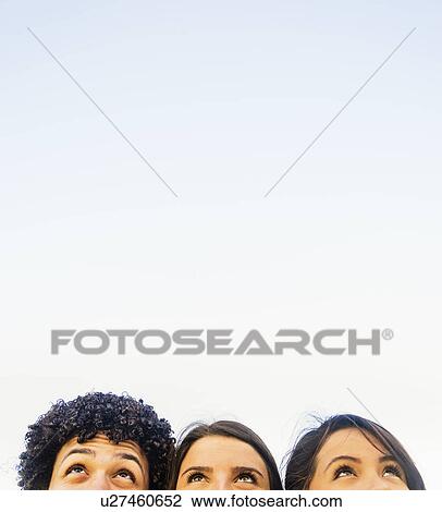 Stock Image - Group of friends (14-15) looking up. Fotosearch
