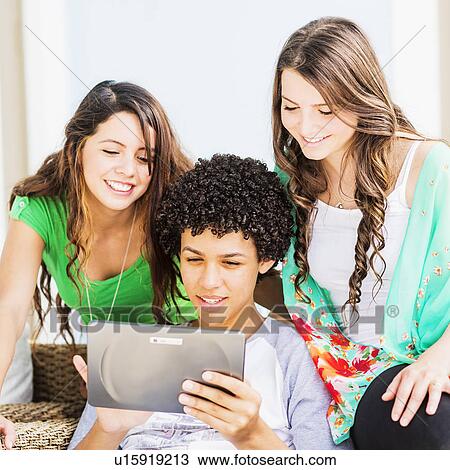 Group of friends (14-15) using digital tablet View Large Photo Image Stock Image - Group of friends (14-15) using digital tablet. Fotosearch