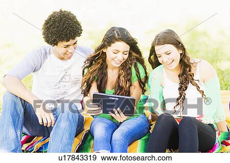 Group of friends (14-15) using digital tablet View Large Photo Image Stock Photo - Group of friends (14-15) using digital tablet. Fotosearch