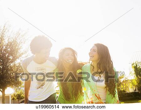Picture - Group of friends (14-15) walking on street and laughing. Fotosearch