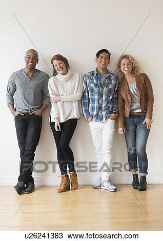 Group of friends standing in front of white wall View Large Photo Image Stock Image - Group of friends standing in front of white wall. Fotosearch