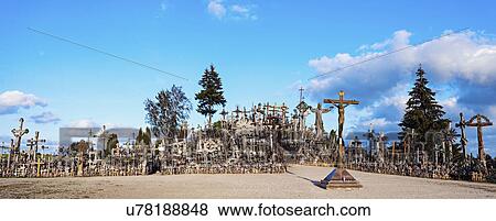 Stock Photo - Hill of crosses under cloudy sky. Fotosearch