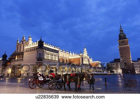 Stock Photo - Horse cart against Cloth Hall on main square. Fotosearch
