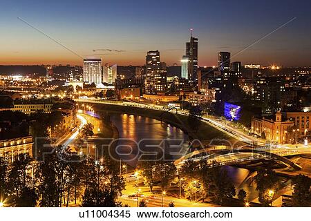 Stock Photography - Illuminated riverfront cityscape seen from elevation on opposite bank. Fotosearch