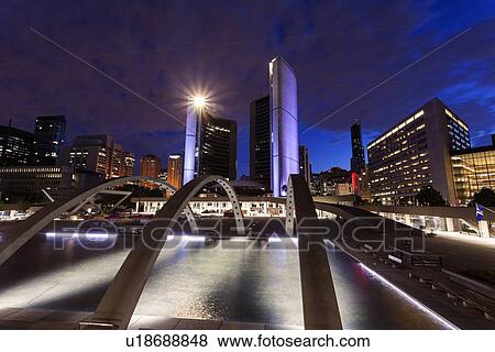 Stock Photo - Illuminated skyline with empty ice rink in foreground. Fotosearch