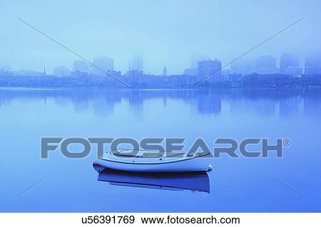 Stock Photo - Lone boat on Charles river on foggy morning. Fotosearch