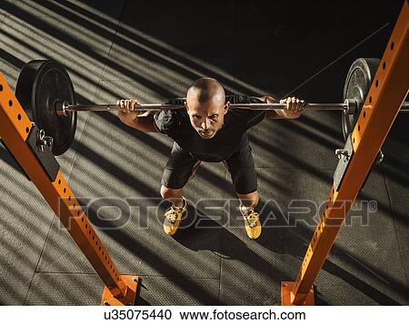 Stock Image - Man doing squats. Fotosearch