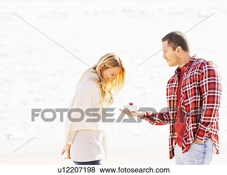 Man giving woman present on beach View Large Photo Image Stock Photo - Man giving woman present on beach. Fotosearch