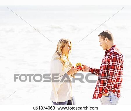 Stock Image - Man giving woman present. Fotosearch