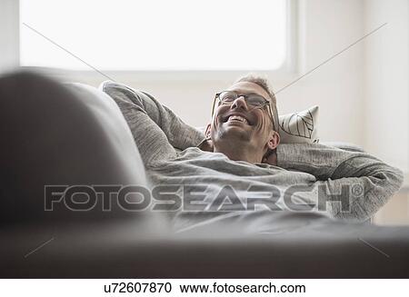 Man lying on sofa View Large Photo Image Stock Image - Man lying on sofa. Fotosearch