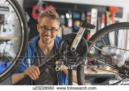 Man repairing bike in shop View Large Photo Image Stock Image - Man repairing bike in shop. Fotosearch