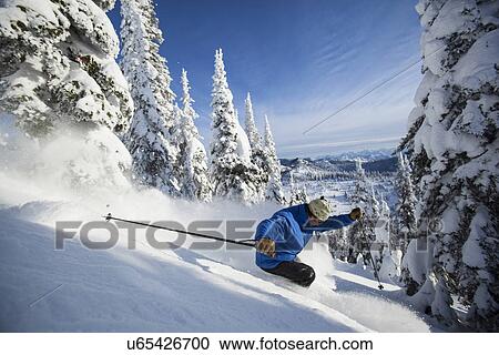 Stock Image - Man skiing in mountains. Fotosearch