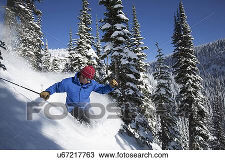 Stock Image - Man skiing in mountains. Fotosearch