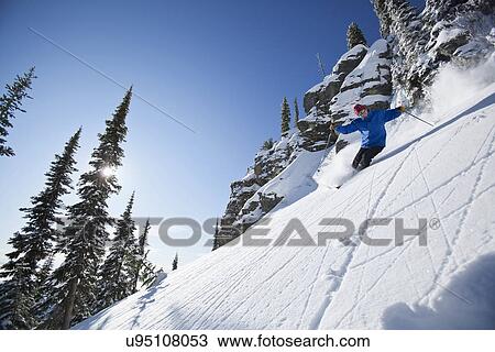 Stock Image - Man skiing in mountains. Fotosearch