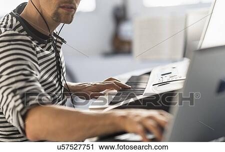 Man using laptop and synth to make music View Large Photo Image Stock Image - Man using laptop and synth to make music. Fotosearch