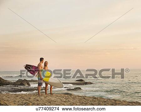 Mid-adult couple talking on beach at sunset View Large Photo Image Picture - Mid-adult couple talking on beach at sunset. Fotosearch