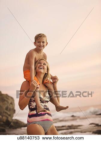 Mother carrying son (6-7) on shoulders outdoors View Large Photo Image Stock Image - Mother carrying son (6-7) on shoulders outdoors. Fotosearch