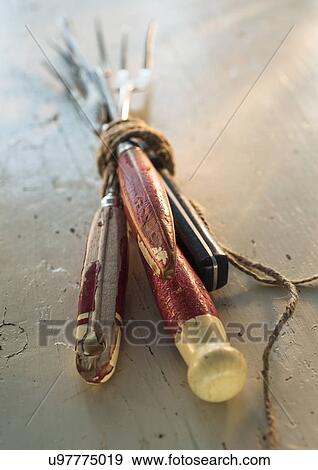Stock Photo - Old kitchen utensils tied with string on white. Fotosearch