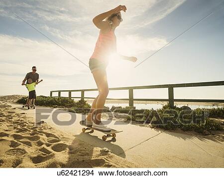 Parents skateboarding with their son (6-7) View Large Photo Image Picture - Parents skateboarding with their son (6-7). Fotosearch