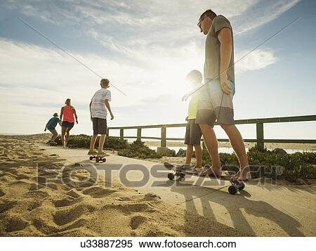Stock Photography - Parents skateboarding with their children (6-7, 10-11, 14-15). Fotosearch
