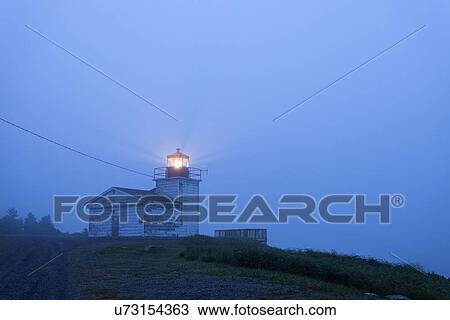 Stock Image - Port Bickerton Lighthouse in fog at dawn. Fotosearch