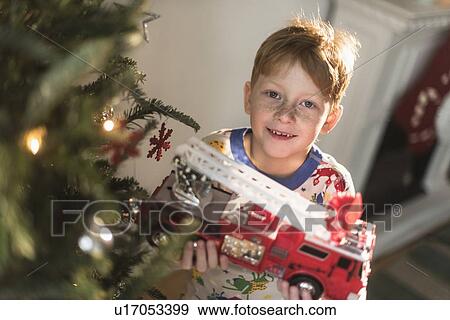 Portrait of boy (6-7) holding toy firetruck View Large Photo Image Stock Photo - Portrait of boy (6-7) holding toy firetruck. Fotosearch