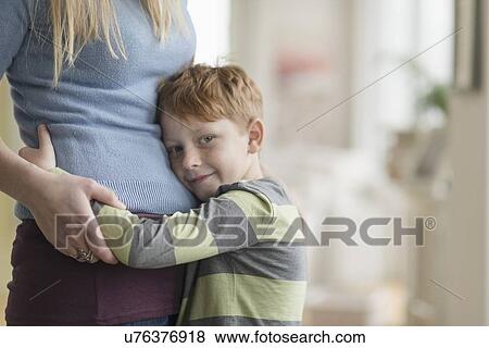 Portrait of boy (6-7) hugging his mother View Large Photo Image Stock Photo - Portrait of boy (6-7) hugging his mother. Fotosearch
