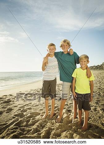 Stock Photography - Portrait of brothers (6-7, 10-11, 14-15) on beach. Fotosearch