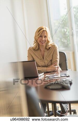 Stock Image - Portrait of business woman in office. Fotosearch