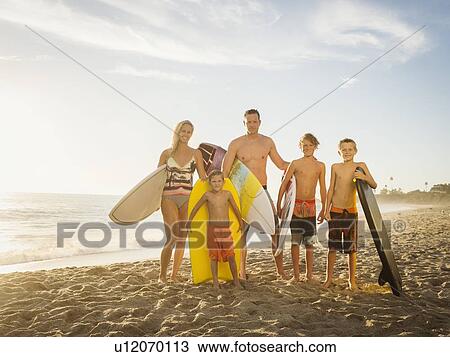 Portrait of family with three children (6-7, 10-11, 14-15) with surfboards on beach View Large Photo Image Stock Image - Portrait of family with three children (6-7, 10-11, 14-15) with surfboards on beach. Fotosearch
