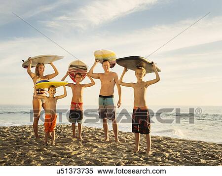 Portrait of family with three children (6-7, 10-11, 14-15) with surfboards on beach View Large Photo Image Stock Photography - Portrait of family with three children (6-7, 10-11, 14-15) with surfboards on beach. Fotosearch