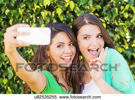 Portrait of female friends (14-15) making selfie View Large Photo Image Stock Photography - Portrait of female friends (14-15) making selfie. Fotosearch