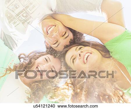 Stock Image - Portrait of friends (14-15) looking down. Fotosearch