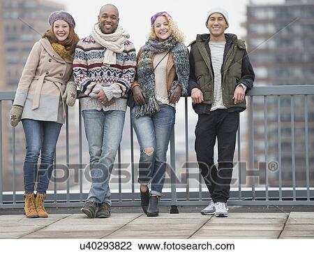 Portrait of happy friends leaning against bridge railing View Large Photo Image Stock Image - Portrait of happy friends leaning against bridge railing . Fotosearch