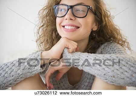 Portrait of smiling young woman wearing glasses View Large Photo Image Stock Image - Portrait of smiling young woman wearing glasses. Fotosearch