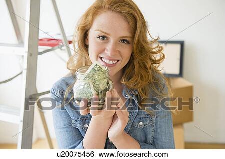 Portrait of woman holding jar with money View Large Photo Image Stock Photograph - Portrait of woman holding jar with money. Fotosearch