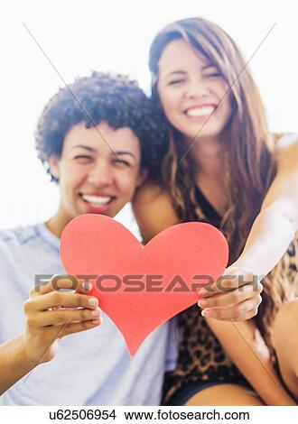 Portrait of young couple with paper heart View Large Photo Image Picture - Portrait of young couple with paper heart. Fotosearch