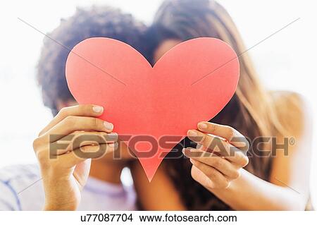Picture - Portrait of young couple with paper heart. Fotosearch