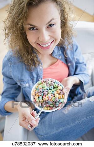 Portrait of young woman eating cereal View Large Photo Image Stock Photo - Portrait of young woman eating cereal. Fotosearch