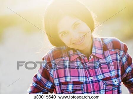 Portrait of young woman in sunlight, smiling View Large Photo Image Stock Image - Portrait of young woman in sunlight, smiling . Fotosearch
