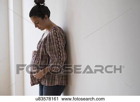 Pregnant woman leaning against wall View Large Photo Image Stock Image - Pregnant woman leaning against wall. Fotosearch