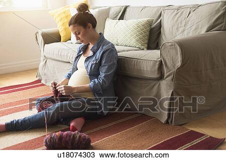 Pregnant woman sitting on floor knitting View Large Photo Image Stock Image - Pregnant woman sitting on floor knitting. Fotosearch