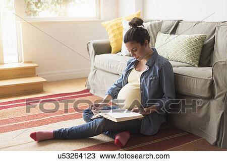 Pregnant woman sitting on floor reading book View Large Photo Image Stock Image - Pregnant woman sitting on floor reading book. Fotosearch
