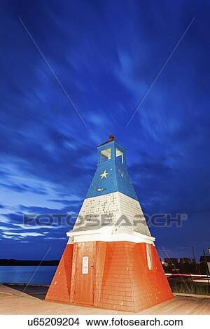 Picture - Small lighthouse under cloudy sky. Fotosearch