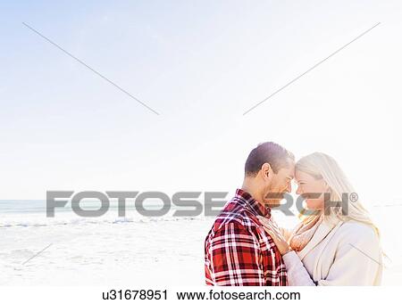 Stock Image - Smiling couple on beach. Fotosearch