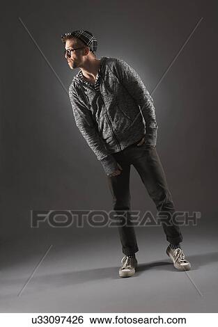 Stock Photograph - Studio shot of man in gray clothing. Fotosearch