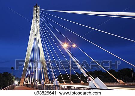 Stock Image - Tower and cables of illuminated Swietokrzyski Bridge against night sky. Fotosearch
