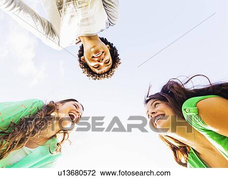 Upward view of friends (14-15) laughing View Large Photo Image Stock Image - Upward view of friends (14-15) laughing. Fotosearch