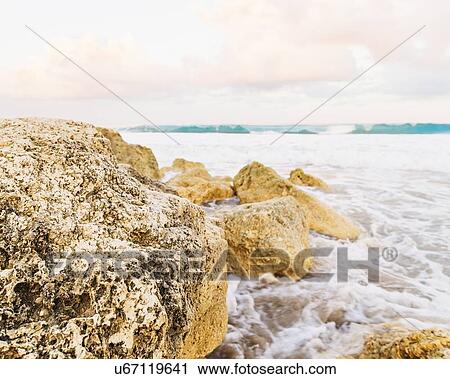 Stock Image - View of rocks and waves at seaside. Fotosearch